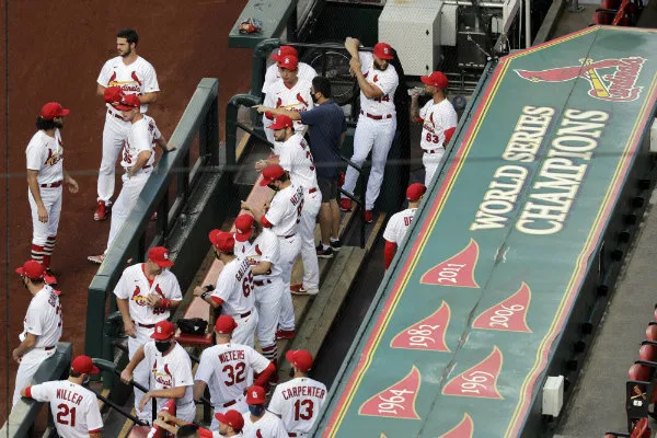 Jugadores de los Cardenales de San Luis a un costado del Bullpen