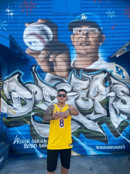 Julio Urías junto a su mural