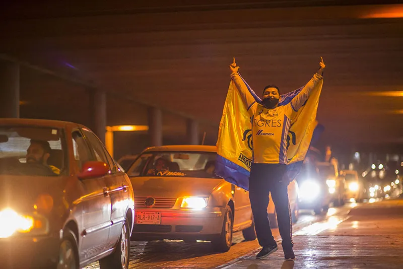Aficionado celebra con una bandera de Tigres
