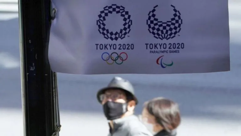 Habitantes de Japón pasan por un cartel de Tokio 2020