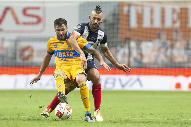 Gignac y Nico Sánchez pelean un balón en el Clásico Regio