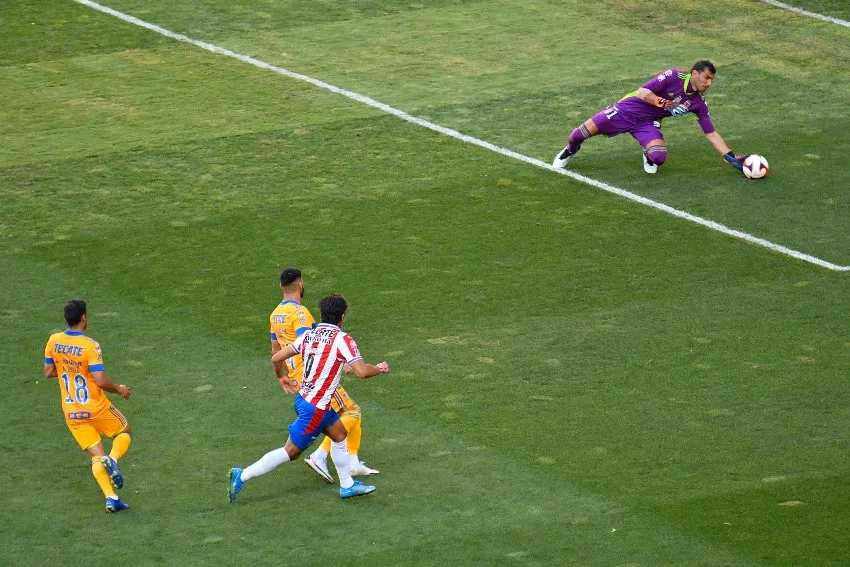 Nahuel Guzmán atajando un disparo de Macías