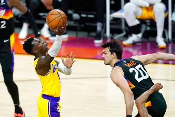 AP Dennis Schroder de los Lakers pasa sobre Dario Saric de los Suns
