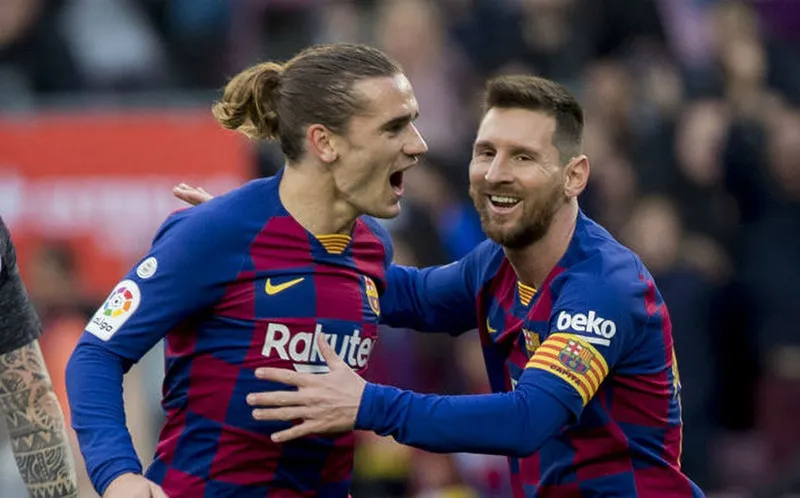 Griezmann y Messi durante un duelo con el Barcelona
