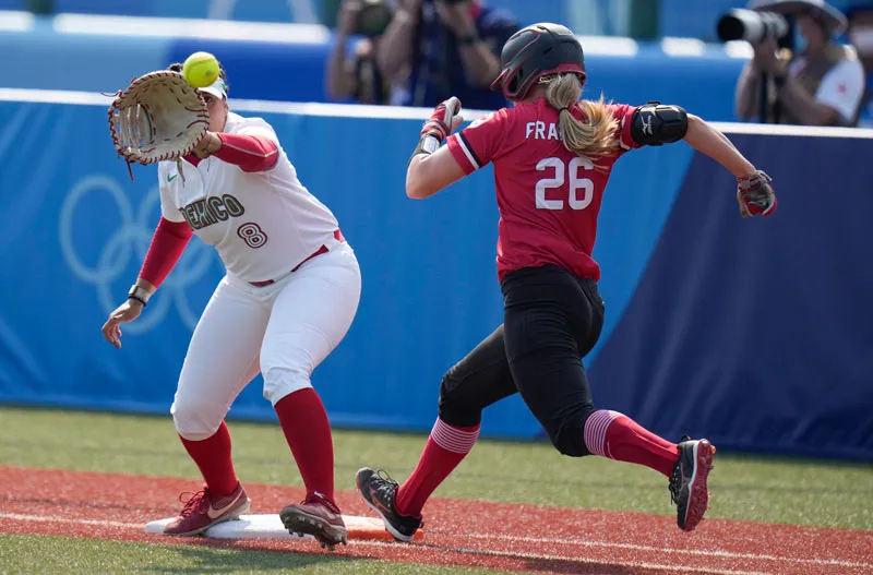 Victoria Vidales atrapa la pelota mientras Larissa Franklin corre a la base