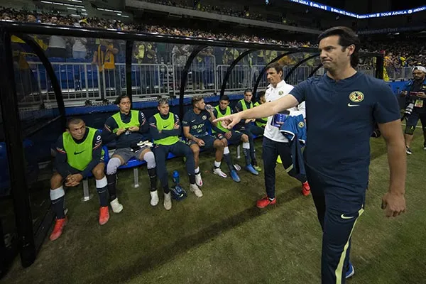 El DT de America junto a sus jugadores de banca