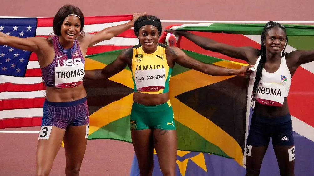 Elaine Thompson-Herah portando la bandera de Jamaica