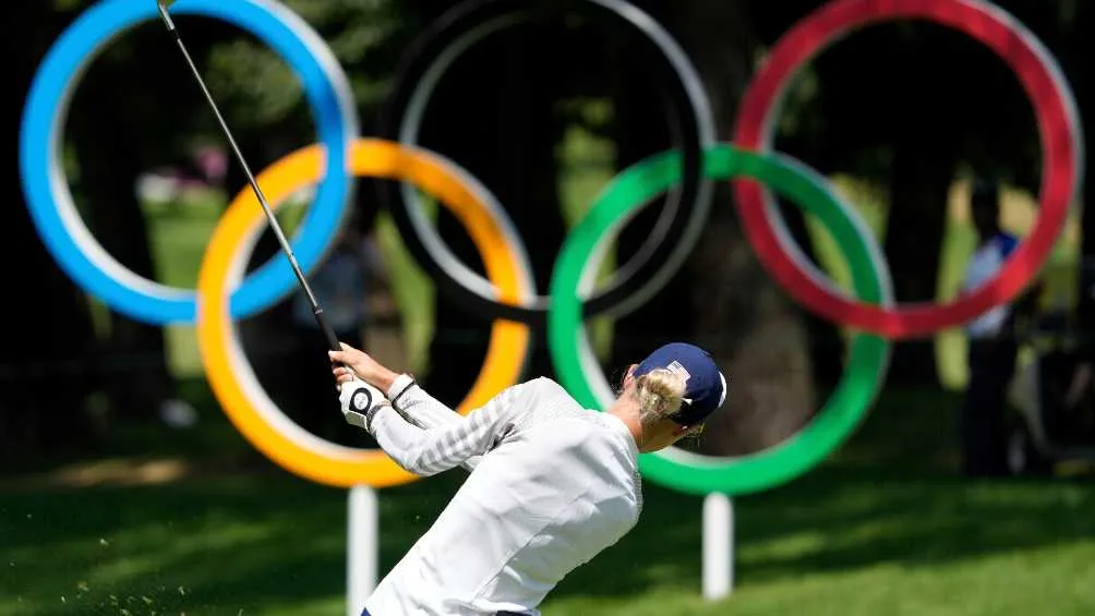Los aros olímpicos de fondo en una competencia de golf en Tokio 2020