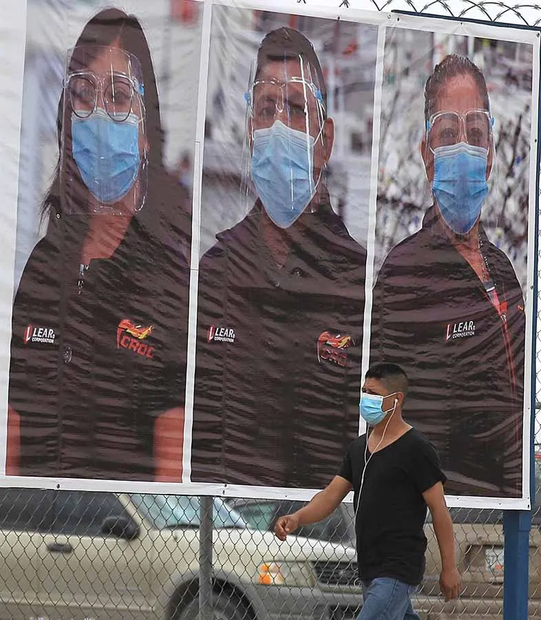 EFE Una persona camina junto a cartel que promueve el uso de cubrebocas en Ciudad Juárez