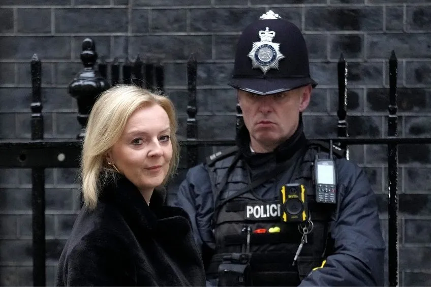 Liz Truss frente a un policía británico