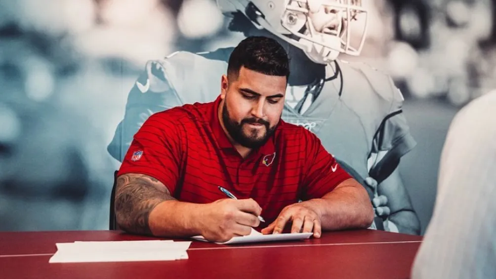 William Hernández firmando su contrato con los Arizona Cardinals
