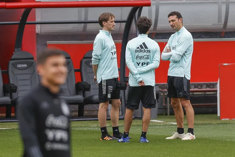 Scaloni platicando con su cuerpo técnico