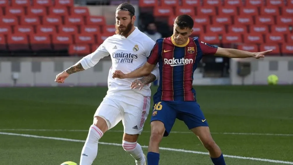 Pedri peleando un balón con Ramos