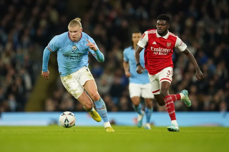 Erling Haaland y Thomas Partey en disputa por el balón