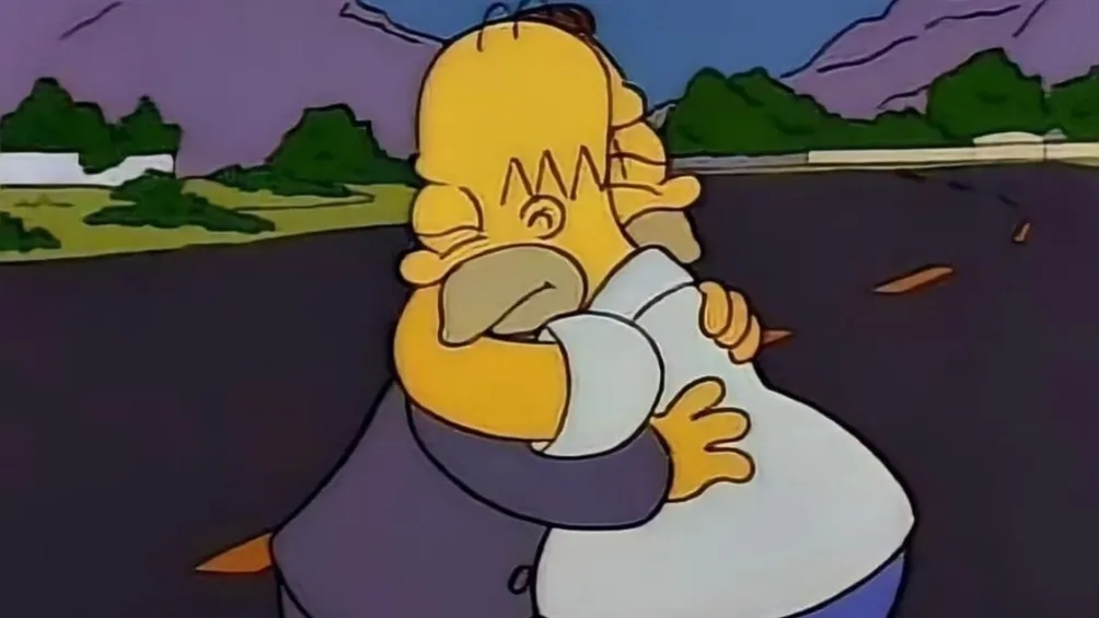 Homero abraza a un hombre a media carretera