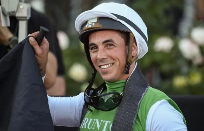 Dean Holland sonriendo junto a su caballo