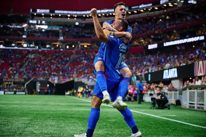 Moisés festeja su gol con Augusto Lotti