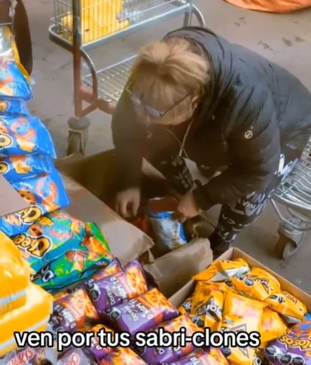 Mujer rellena bolsa de Cheetos con la mano