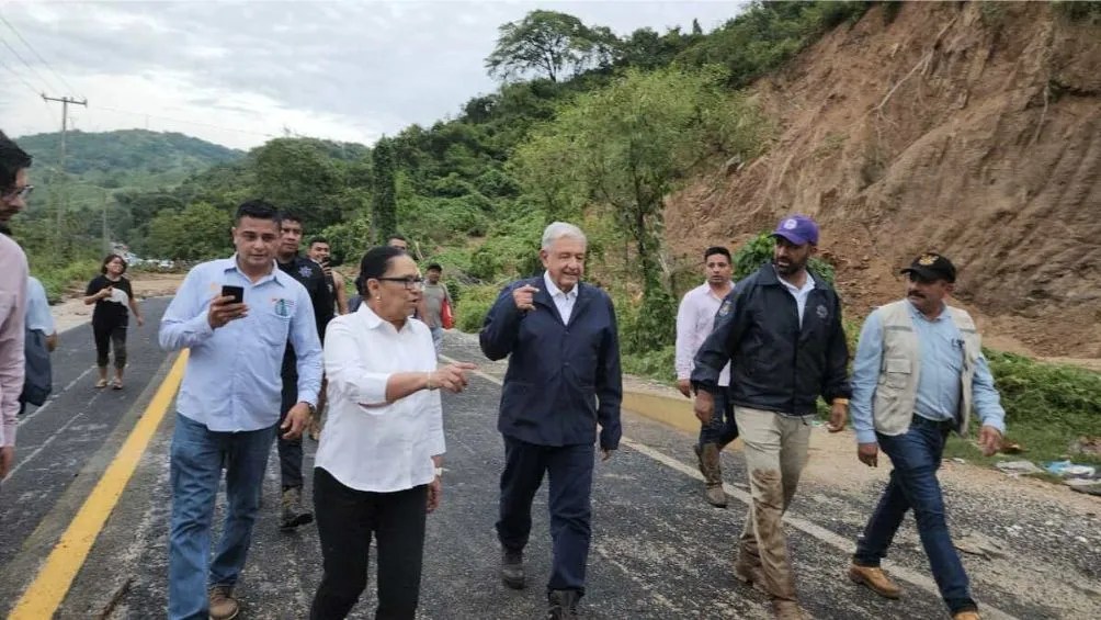 AMLO caminando sobre el tramo carretero donde se atoró