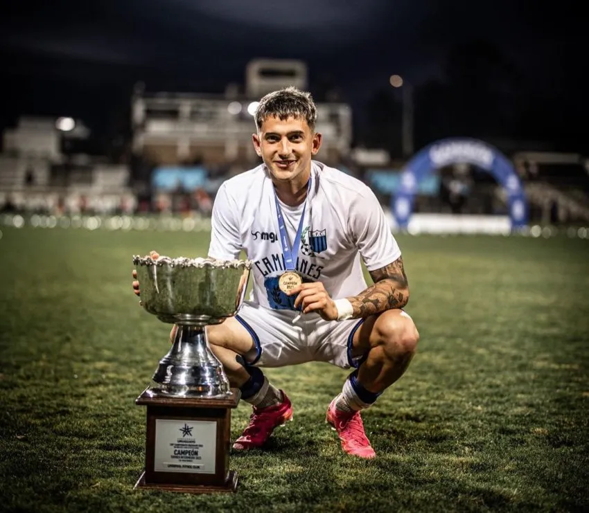 Con el trofeo en el campo