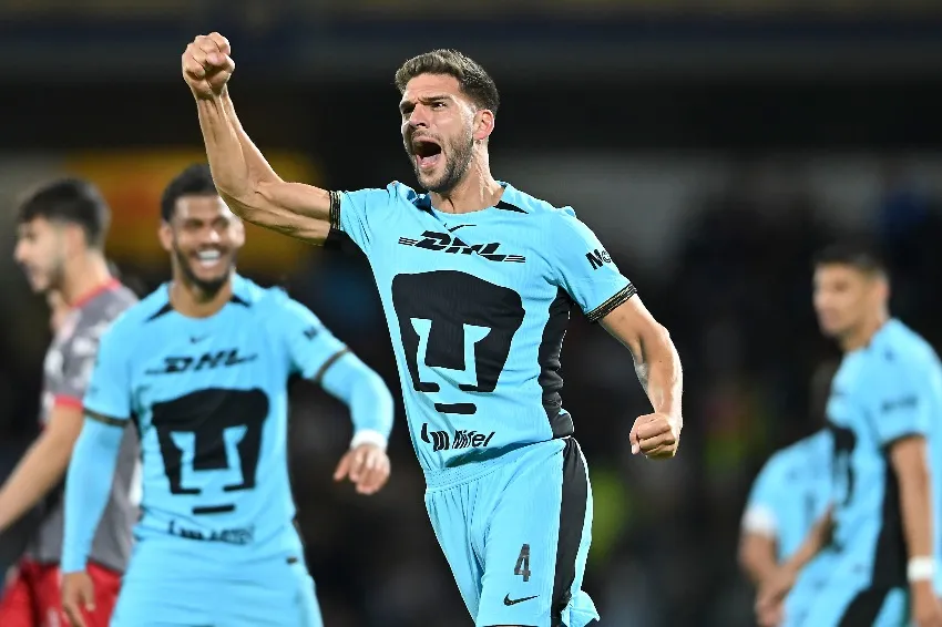 Pumas en celebración de gol en CU en la noche