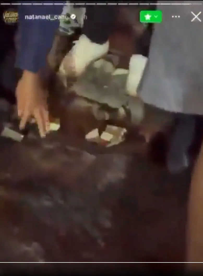 Otro video muestrá como agentes levantan el dinero que el cantante les arrojó.