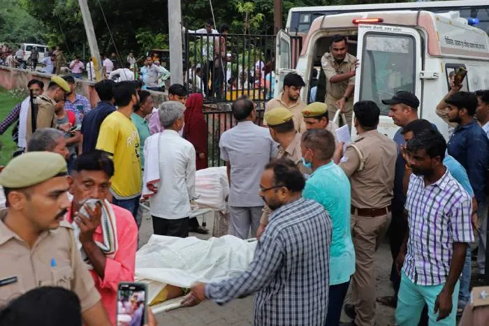 AP Familiares y voluntarios llevan los cuerpos en camillas en el hospital Sikandrarao en el distrito de Hathras