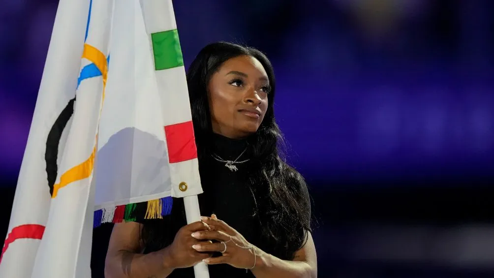AP Simone Biles recibe la bandera Olímpica