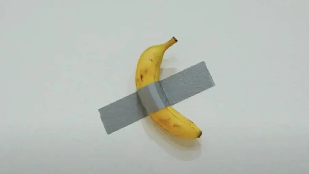 La obra de arte conceptual &quot;Comedian&quot;, que consiste en una banana pegada a una pared con cinta adhesiva, se vendió por 6.2 millones de dólares en una subasta de Sotheby’s.
