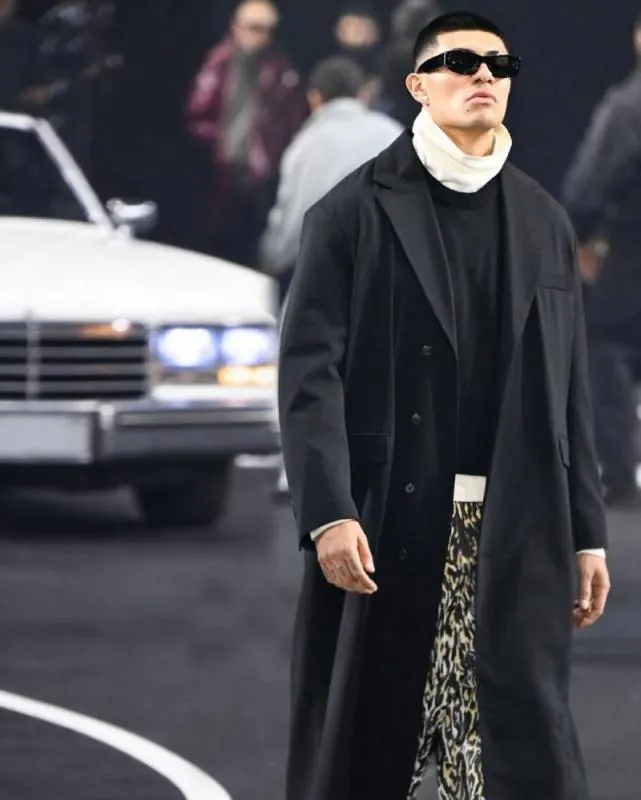 El Bogueto lució un abrigo negro y pantalones con estampado, combinando elegancia y estilo callejero. / @elbogueto