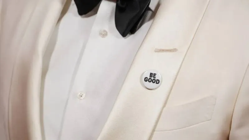 Celebridades utilizaron pines con mensajes como “Be Good” e “ICE Out” en recuerdo de Renee Nicole Good./ AP