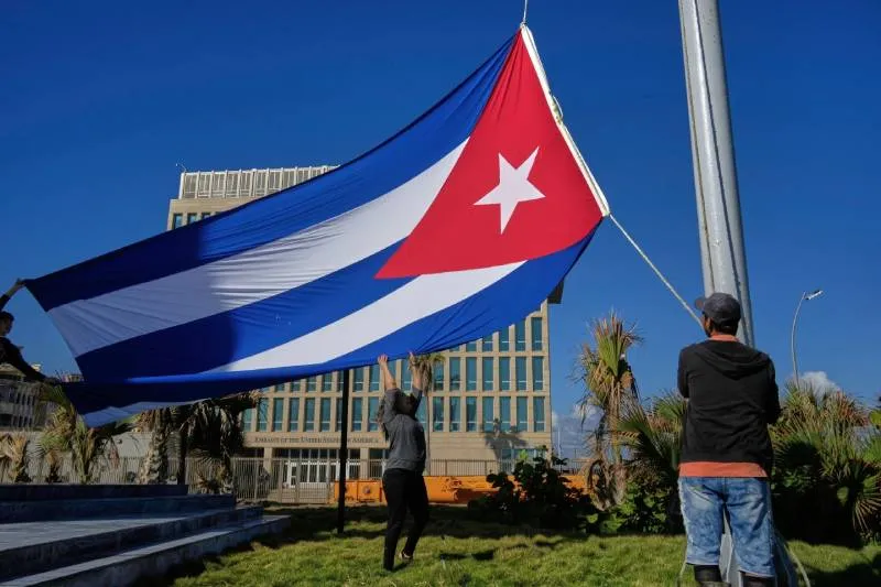Trabajadores enarbolan la bandera cubana a media asta en el Tribuno Antiimperialista cerca de la embajada de EE.UU en La Habana, Cuba. / AP