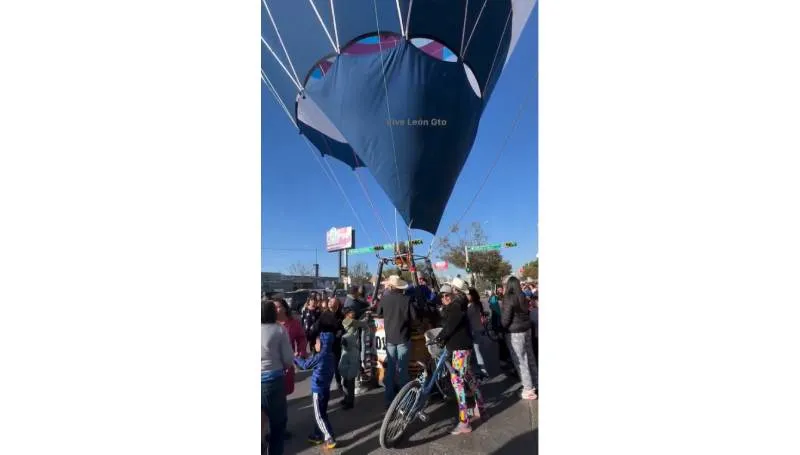 Vecinos y automovilistas ayudan a estabilizar un globo aerostático que perdió altitud en una vialidad de León. / Redes sociales