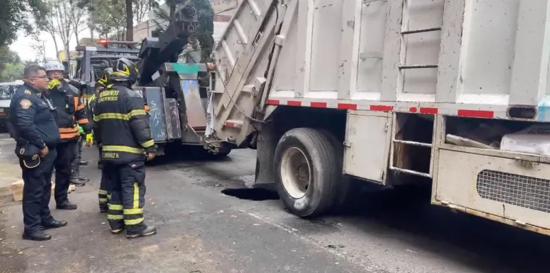 Con una grúa especial lograron sacar el camión de basura del socavón / Redes Sociales