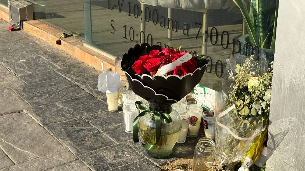 un arreglo floral con un listón que decía &quot;Perdón&quot; fue colocado en la entrada del salón de belleza donde fue asesinada la influencer. / Telediario