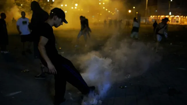 Aficionado húngaro patea una bomba de gas lacrimógeno durante altercados 