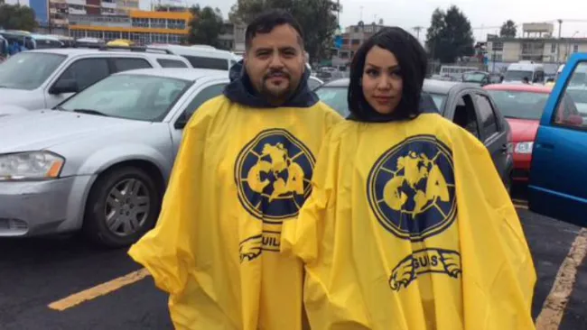 Aficionados muestran hasta en el impermeable su pasión por América