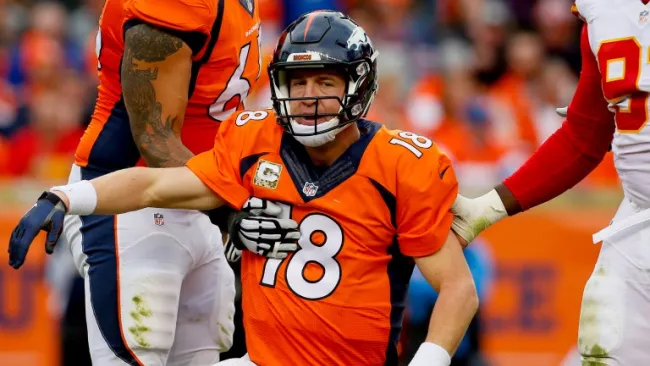Manning es ayudado por jugadores para incorporarse