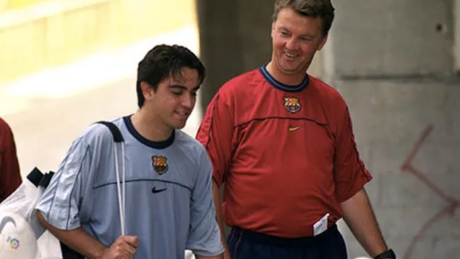 Xavi camina junto a Van Gaal 