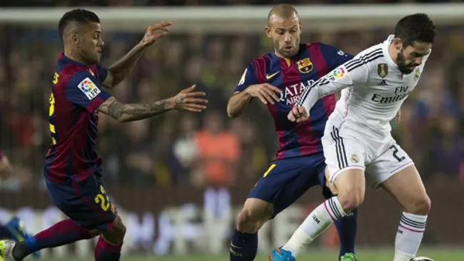 Alves, Mascherano e Isco disputan el balón