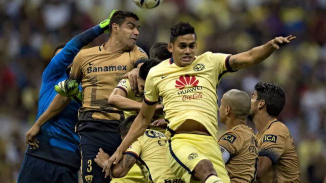 Jugadores de América y Pumas buscan un balón aéreo