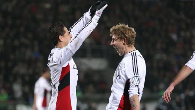 Chicharito se abraza con Kiessling tras anotar en la DFB Pokal