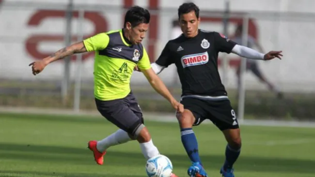 Bravo compite por el esférico con un rival