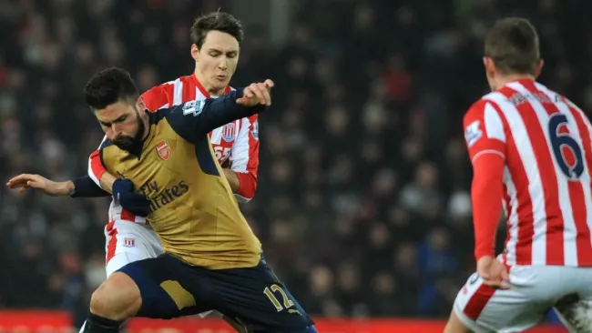 Olivier Giroud pelea un balón con los jugadores del Stoke City