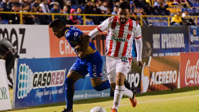Juan Castro y Luis Gallegos pelean por el balón