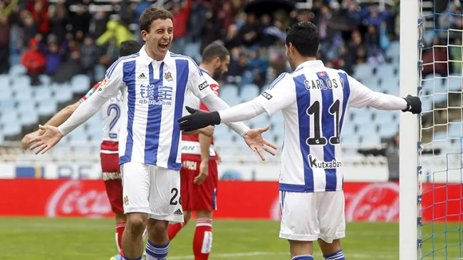 Carlos Vela festeja con Oyarzábal tras un gol