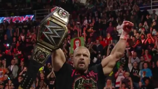 Triple H festeja depsués de atacar a Roman Reigns 
