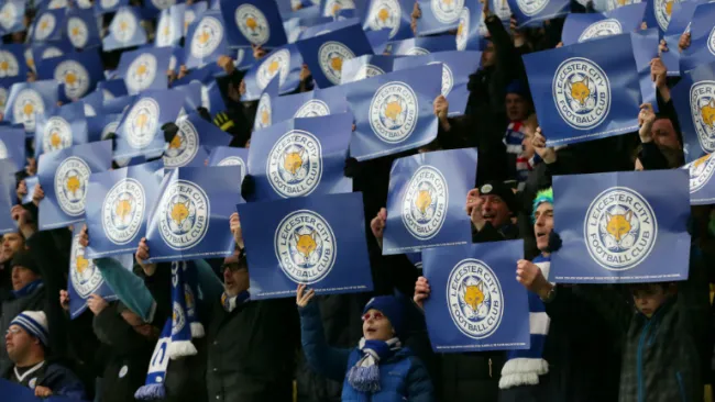 Aficionados del Leicester posan con pancartas del equipo