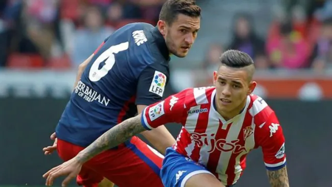 Koke intenta frenar a un jugador del Sporting