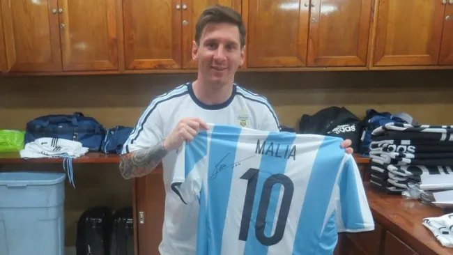 Lionel Messi sostiene una de las playeras que obsequió a la familia Obama